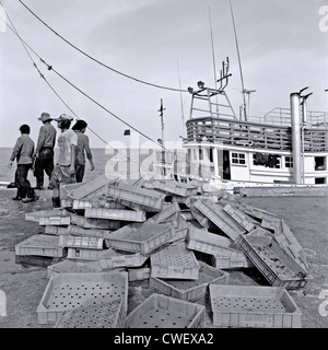 Thai Fisherman mit leeren Trays nach Entladen der täglichen Fang. Hua Hin Thailand Hafen S. E. in Asien die Schwarz-Weiß-Fotografie Stockfoto