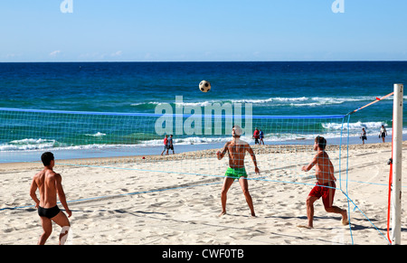 Touristen, die Brasilianer spielen Beachvolleyball Fußball Surfers Paradise Beach Stockfoto