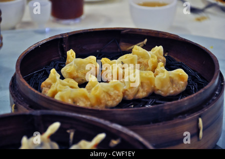 leckere gedämpfte chinesische Dim-Sum in einem Bambuskorb serviert Stockfoto