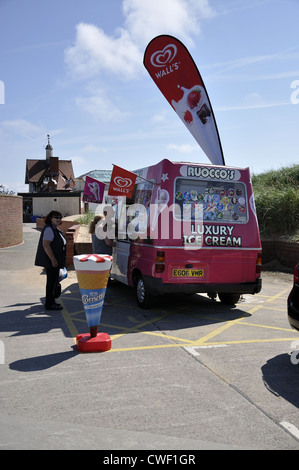 Rosa und weiße Eis mit langen ovalen Schild Werbung im heißen August in Lytham St Annes Rückansicht zeigt frei stehende Anzeige Kegel Stockfoto