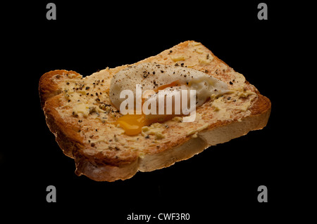 TOAST MIT VERSCHIEDENEN TOPPINGS SCHUSS AUF SCHWARZEM HINTERGRUND BOHNEN, MARMELADE, KÄSE, EI, ESSEN, SCHNELLES ESSEN, EINFACHES ESSEN, FAST FOOD, GUTES ESSEN. Stockfoto