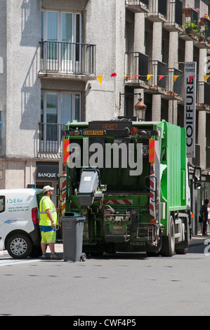 Man leert wheely Lagerplätze in einen LKW in Pau Stadtzentrum Südwest-Frankreich Stockfoto