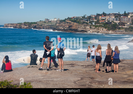 Menschen stehen und sitzen auf den Felsen über Tamarama Beach blickte Küste in Richtung Bronte Sydney New South Wales Australien Stockfoto