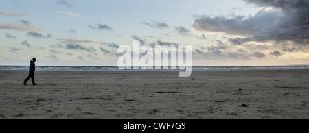 Mann geht am Strand im wind Stockfoto