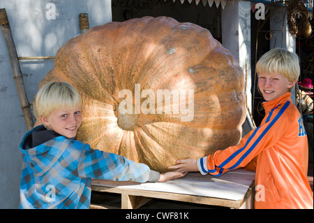 Kinder bewundern einen riesigen Kürbis auf einem Farmstall in Worcester, Western Cape, Südafrika Stockfoto