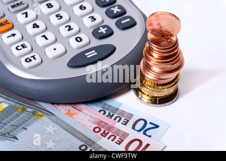 Detailansicht der Euro-Münzen und Banknoten mit einem Rechner so nah Blick auf weißem Hintergrund Stockfoto