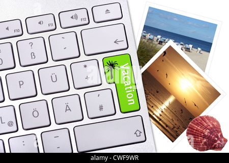 Computer-Tastatur-Taste mit der Bezeichnung Urlaub, zwei Fotos und eine Muschel auf einem weißen Hintergrund Stockfoto