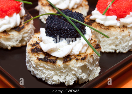 Roten und schwarzen Kaviar Kanapees dekoriert mit Schnittlauch. Stockfoto