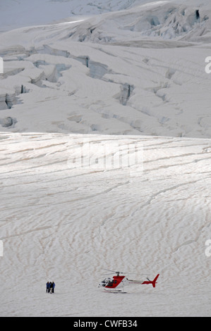 Eine kleine Gruppe von Touristen steht in der Nähe eines Helikopters, der Sehenswürdigkeiten in der Nähe des 12 km langen Franz-Josef-Gletschers im Westland Tai Poutini National ansieht Stockfoto