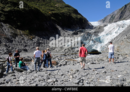 Besucher kommen zusammen, um den Franz-Josef-Gletscher mit seiner Mischung aus Felsen und Eis zu bewundern, der auf dem 12 km langen Gletscher nahe der 12 km den Talboden erreicht Stockfoto