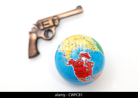 Globus und Pistole auf weißem Hintergrund - Kriminalität und der Welt Stockfoto