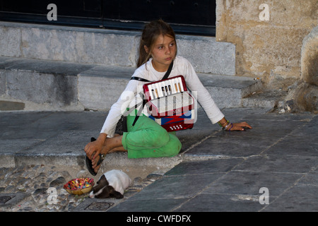 Ein Straßenmusikant auf Rhodos Altstadt spielen für Geld von Touristen auf der Durchreise mit ein Hündchen auf der Insel Rhodos, Ägäis, Stockfoto