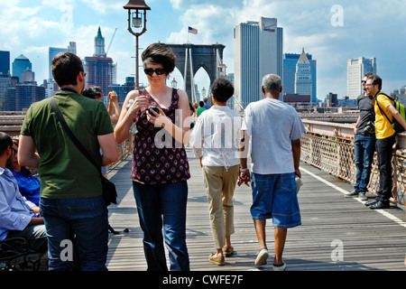 NEW YORK CITY-Mai 31, 2009: Menschen zu Fuß über die Brooklyn Bridge in New York City. Skyline von Manhattan ist im Hintergrund. Stockfoto