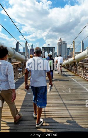 NEW YORK CITY-Mai 31, 2009: Menschen zu Fuß über die Brooklyn Bridge in New York City. Skyline von Manhattan ist im Hintergrund. Stockfoto