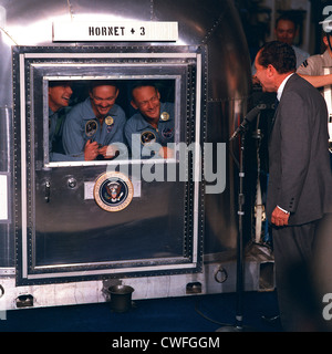 US-Präsident Richard Nixon begrüßt die Apollo 11 Astronauten an Bord der USS Hornet nach Hause nach der Rückkehr von ihrem historischen Flug zum Mond 24. Juli 1969 im Pazifischen Ozean. Die Astronauten beschränkt sich auf die Mobile-Quarantäne-Station (von links nach rechts) Neil A. Armstrong, Kommandant; Michael Collins, Befehl Modul-Pilot; und Edwin E. Aldrin Jr., Pilot der Mondlandefähre. Stockfoto