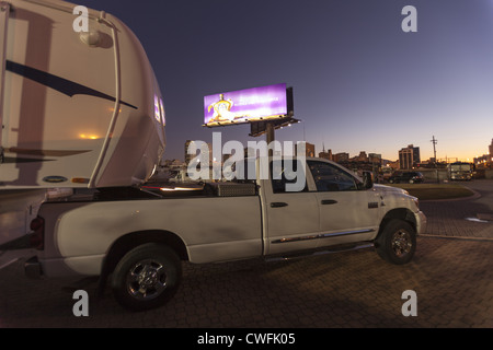 Sattelkupplung RV und Dodge Truck mit New Orleans French Innenstadt im Hintergrund mit einem großen Neon Werbung Schild oben Stockfoto