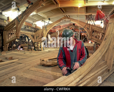 Tischler arbeitet an einem Eichenbalken in Hampton Court Palace, London. Stockfoto