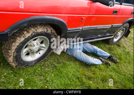 Mann arbeitet unter Land Rover Discovery bei jährlichen Eastnor Land Rover zeigen Herefordshire England UK Stockfoto