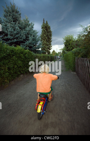 Berlin, geht ein kleines Kind auf seinem Fahrrad in einem Gewitter Wetter Stockfoto