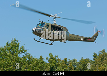 Eine restaurierte Vietnam-Ära US Huey Hubschrauber, ausgestattet mit einem M60 MG, machen eine schnellere Start nach einem Sturz eine Infanterie-Kontingent. Stockfoto