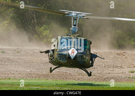 Eine restaurierte Vietnam-Ära US Huey Hubschrauber, ausgestattet mit einem M60 MG, machen eine schnellere Start nach einem Sturz eine Infanterie-Kontingent. Stockfoto