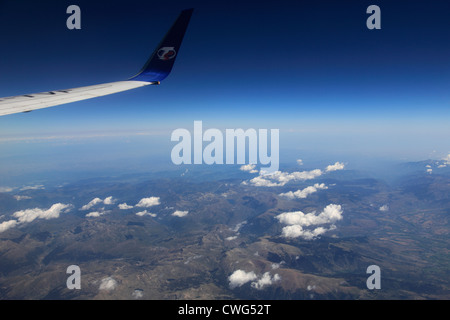 Blick aus dem Flugzeug Fenster TS Airlines Logo und Flügel, französischen Pyrenäen Gebirge mit Altocumulus Stratiformis Wolken. Stockfoto
