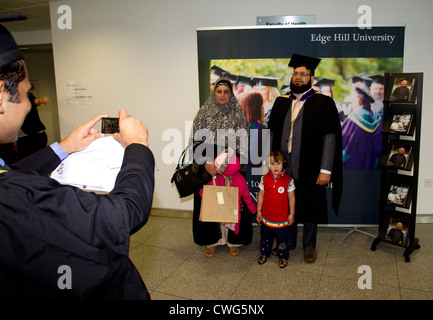 Edge Hill University Graduation Day für Erwachsener muslimische Schüler mit seiner Familie nach fotografieren Stockfoto