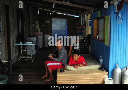 Malaysia, Borneo, Semporna, Mabul, junge Erwachsene, die Gitarre zu spielen Stockfoto