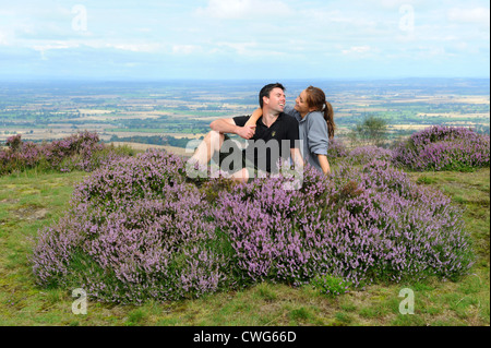 Lächelnde paar sitzt durch die Heide auf Wrekin Hügel in Shropshire, England Uk Stockfoto