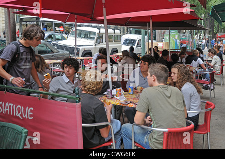 Junge Menschen genießen eine Pause im Straßencafé auf Victor Hugo Boulevard Nimes France Stockfoto