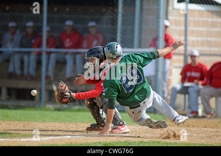 Baseball Schiebetüren Player aus dem Boden Mühe macht Score vor der werfen Home bei einem High School Spiel zu. USA. Stockfoto