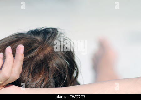 Heckansicht des entspannenden junge Frau am Sandstrand mit Textfreiraum. Stockfoto
