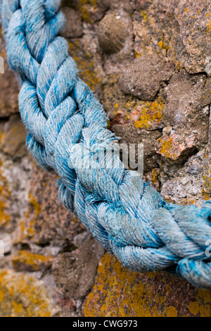 Alten Seil auf einer Hafenmauer. Stockfoto