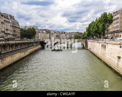 Ein Tour-Bus vorbei unter einer Brücke auf der Seine in Paris Stockfoto