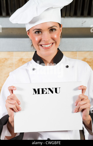 schöne Köchin mit Menü in Küche Stockfoto