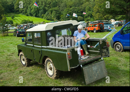 Lady-Lesebuch hinter restaurierten Land Rover 4 x 4 Pickup an der jährlichen Eastnor Land Rover zeigen Herefordshire England UK Stockfoto