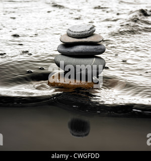 Steine auf dem Wasser Kieselsteine am Strand mit Flut. Steine auf fließendem Wasser Stockfoto