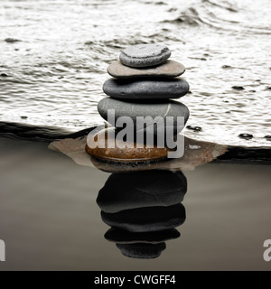 Steine auf dem Wasser Kieselsteine am Strand mit Flut. Steine auf fließendem Wasser Stockfoto