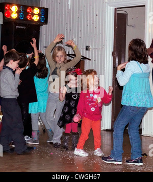 Kinder tanzen in einer Disco mit Schaum in einen fünften Geburtstag feiern England Stockfoto