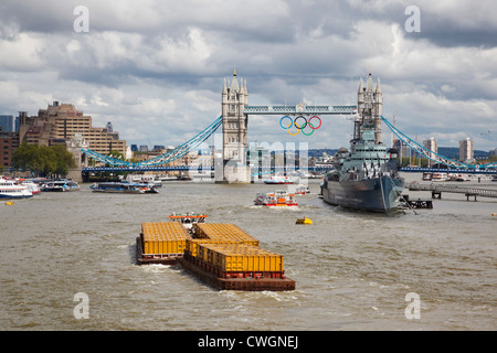 Thames River Lastkahn, der seinen Weg in Richtung Tower Bridge, vorbei an HMS Belfast. London, England Stockfoto