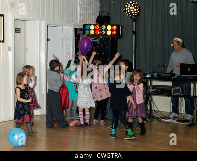 Kinder tanzen mit Luftblasen in einer Diskothek in einer fünften Geburtstag feiern England Stockfoto