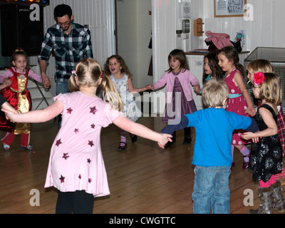 Kinder tanzen tut der Hokey Cokey in einer Diskothek an einem fünften Geburtstag Party England Stockfoto