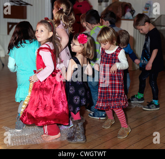 Kinder tanzen auf Bubble Wrap in einer Diskothek an einem fünften Geburtstag Party England Stockfoto