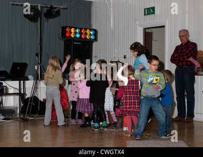 Kinder tanzen in einer Disco mit Schaum in einen fünften Geburtstag feiern England Stockfoto