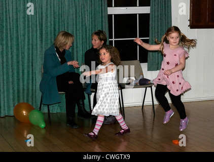 Kinder tanzen, vorbei an Eltern in einer Diskothek an einem fünften Geburtstag Party England überspringen Stockfoto