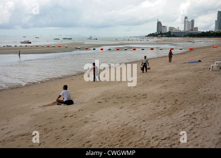 Strandverkäufer zu Fuß entlang einer fast menschenleeren Strand in der Nebensaison, Pattaya Thailand Stockfoto