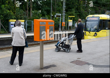 Passagiere, einschließlich des Menschen, gebunden Frau und ein Kind wartet auf die Plattform für die Picadilly Metrolink-Straßenbahn in manchester Stockfoto