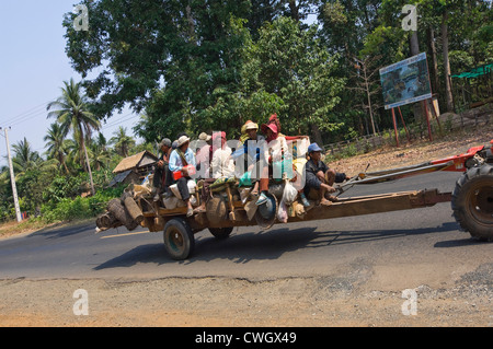 Horizontale Sicht auf eine Straßenszene in Kambodscha mit Landarbeitern auf eine lange chassised Traktor, aka Cgo Yong oder Roboter-Kuh. Stockfoto