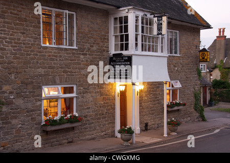 Englische Pubs. Das Acorn Inn in Dorset Dorf von Evershot. Eine Dorfkneipe, Hotel und Restaurant, seine freundlichen Lichter leuchten am Abend. England. Stockfoto