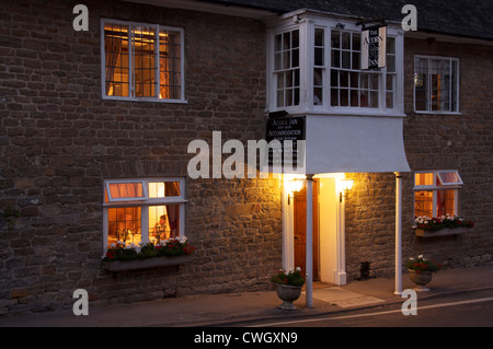 Englische Pubs. Das Acorn Inn in Dorset Dorf von Evershot. Eine Dorfkneipe, Hotel und Restaurant, seine freundlichen Lichter leuchten am Abend. England. Stockfoto